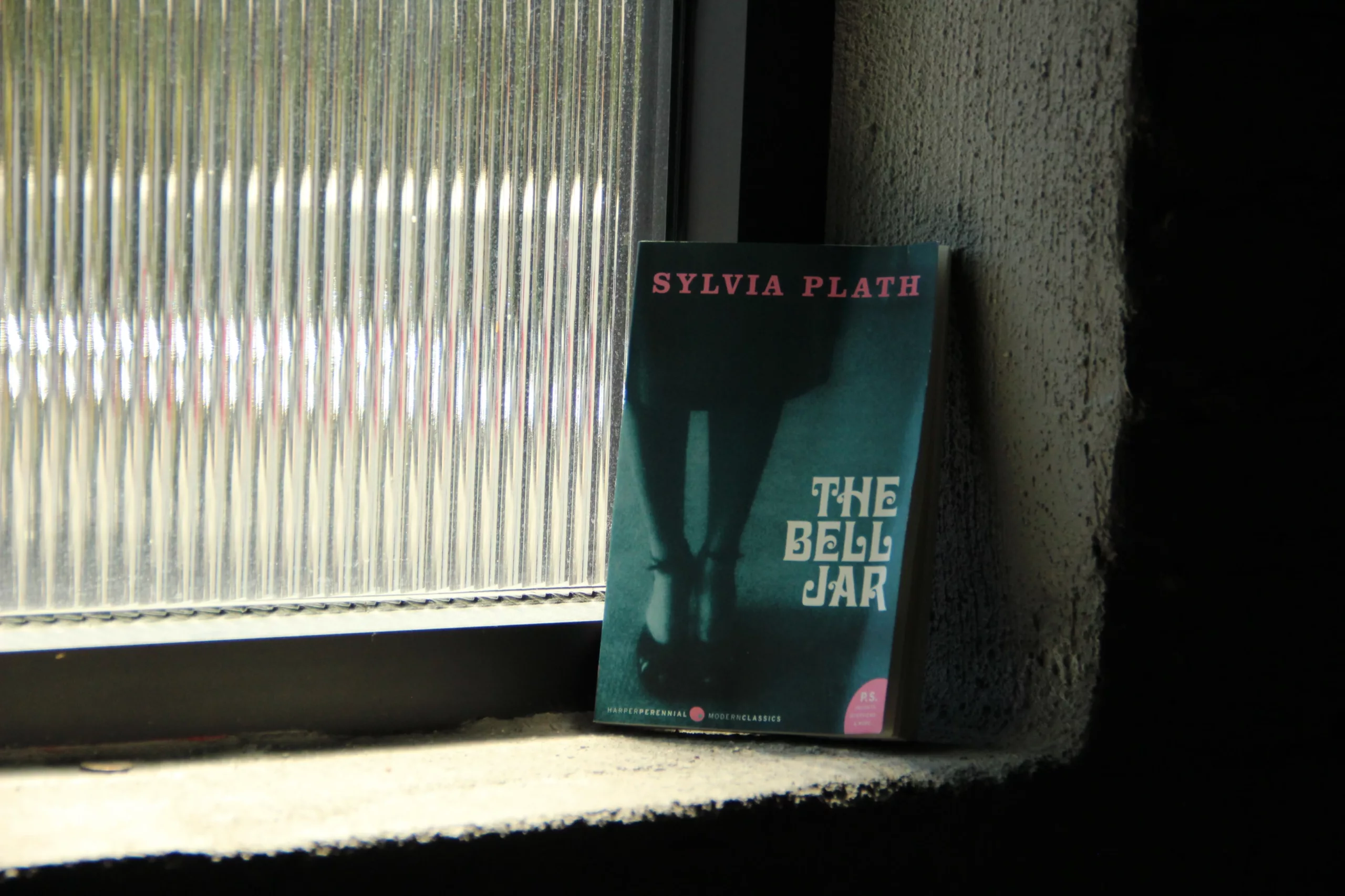 the bell jar paperback book on window sill