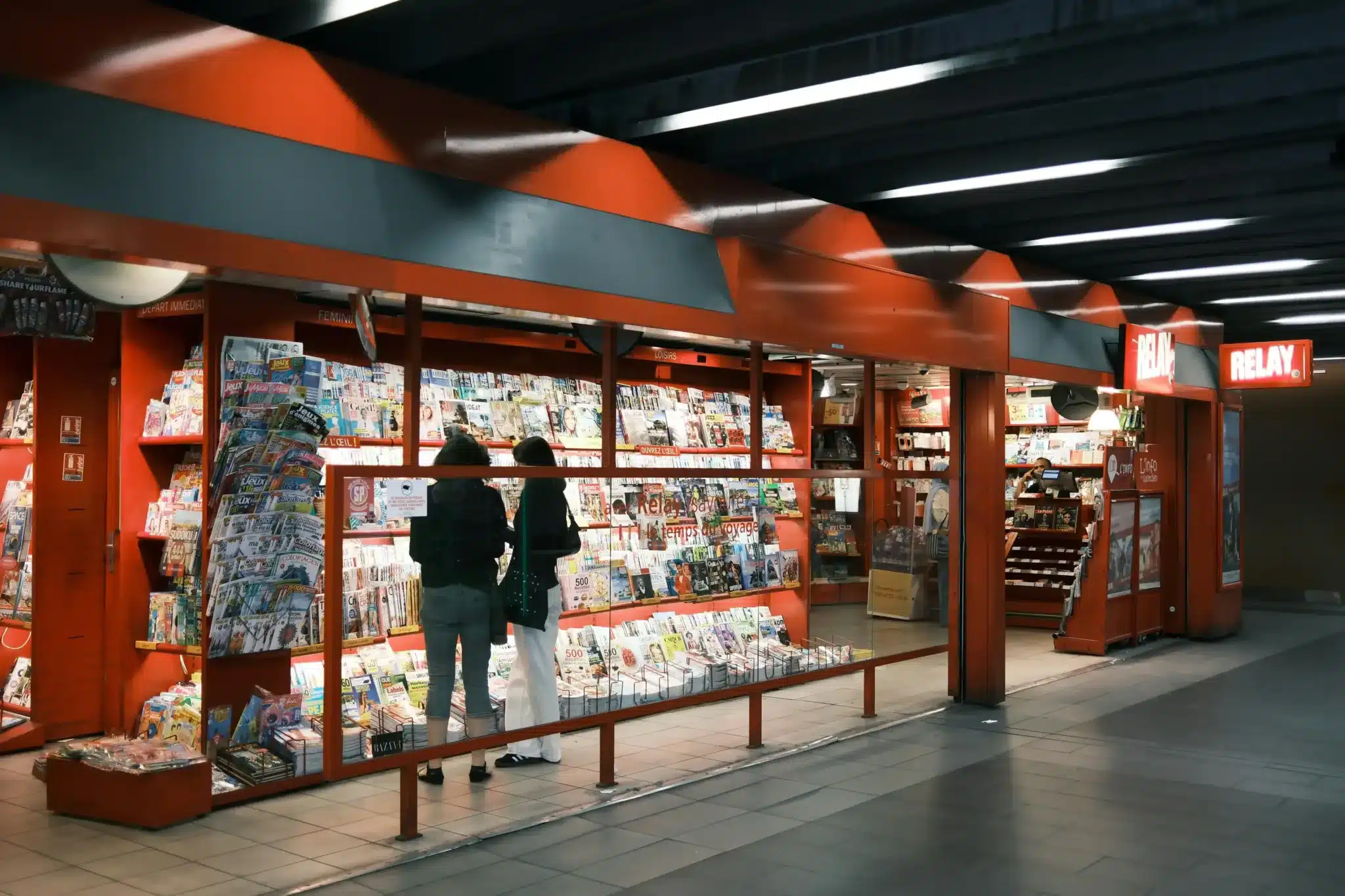 Two Women at a Magazine Stand