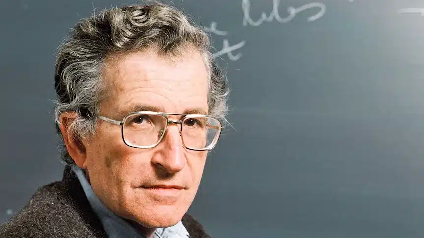 Noam Chomsky in front of a chalkboard