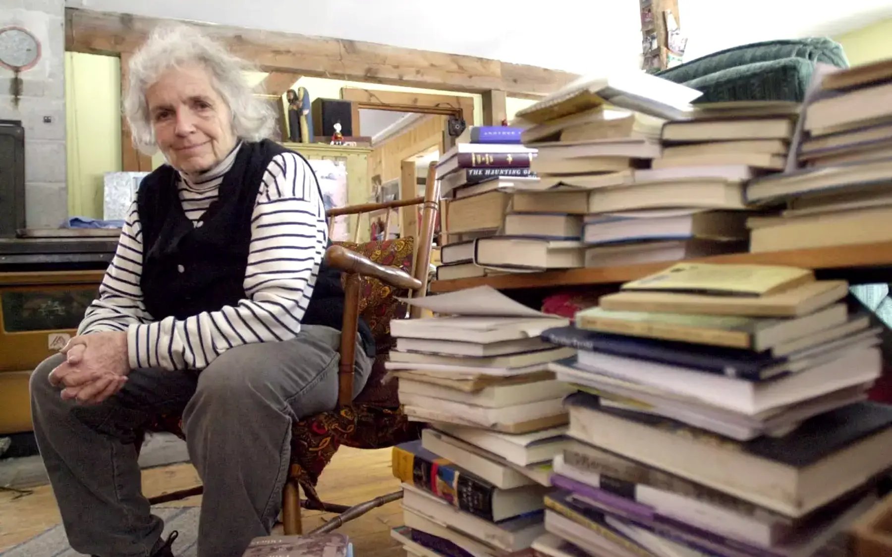 A Photo of Author Grace Paley With Stacks of Books