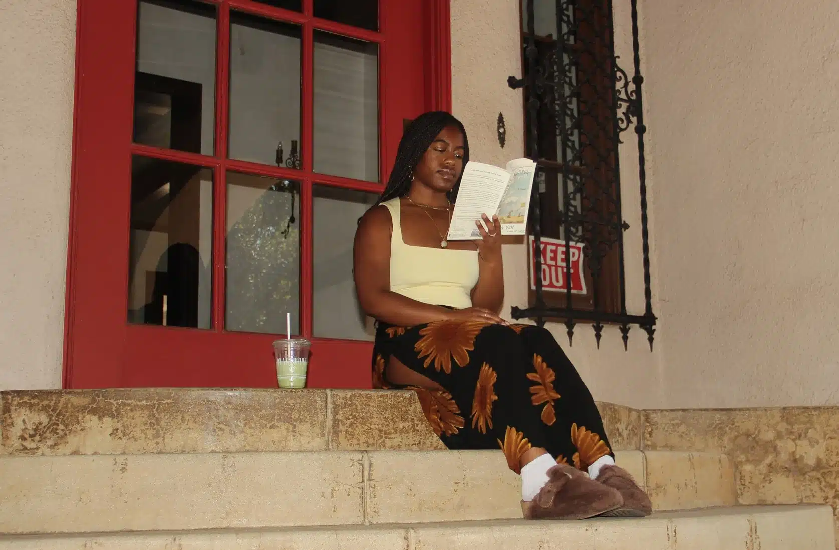 A Woman Reading a Book on a Stoop