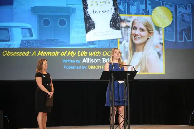 Allison Britz Speaking on Stage at a Conference