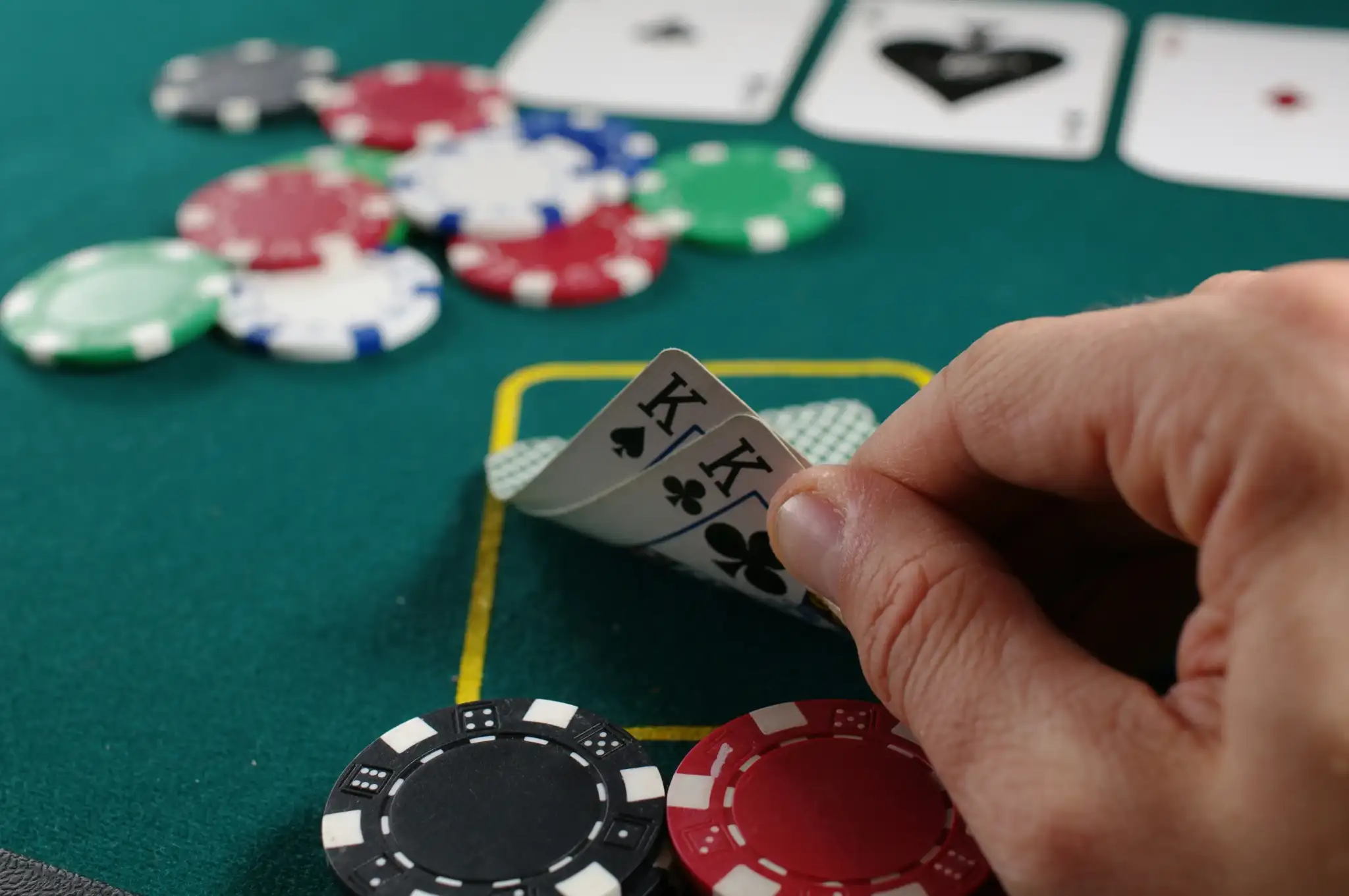 A Man Peeking at His Cards During a Poker Game