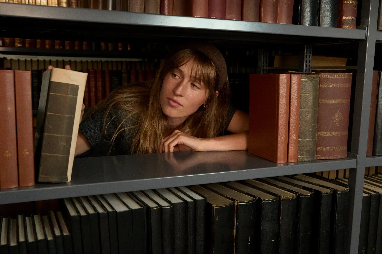 A Woman Browsing Books on a Library Shelf
